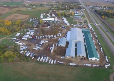 An aerial view of an arena-like farm with a lot of trailers.